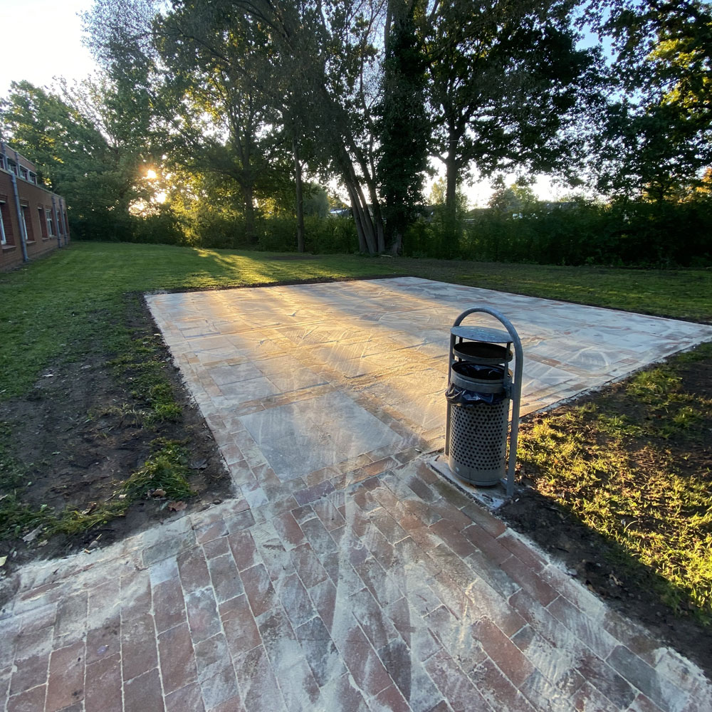 Eine neu gepflasterte Fläche inmitten gemähtem Rasen